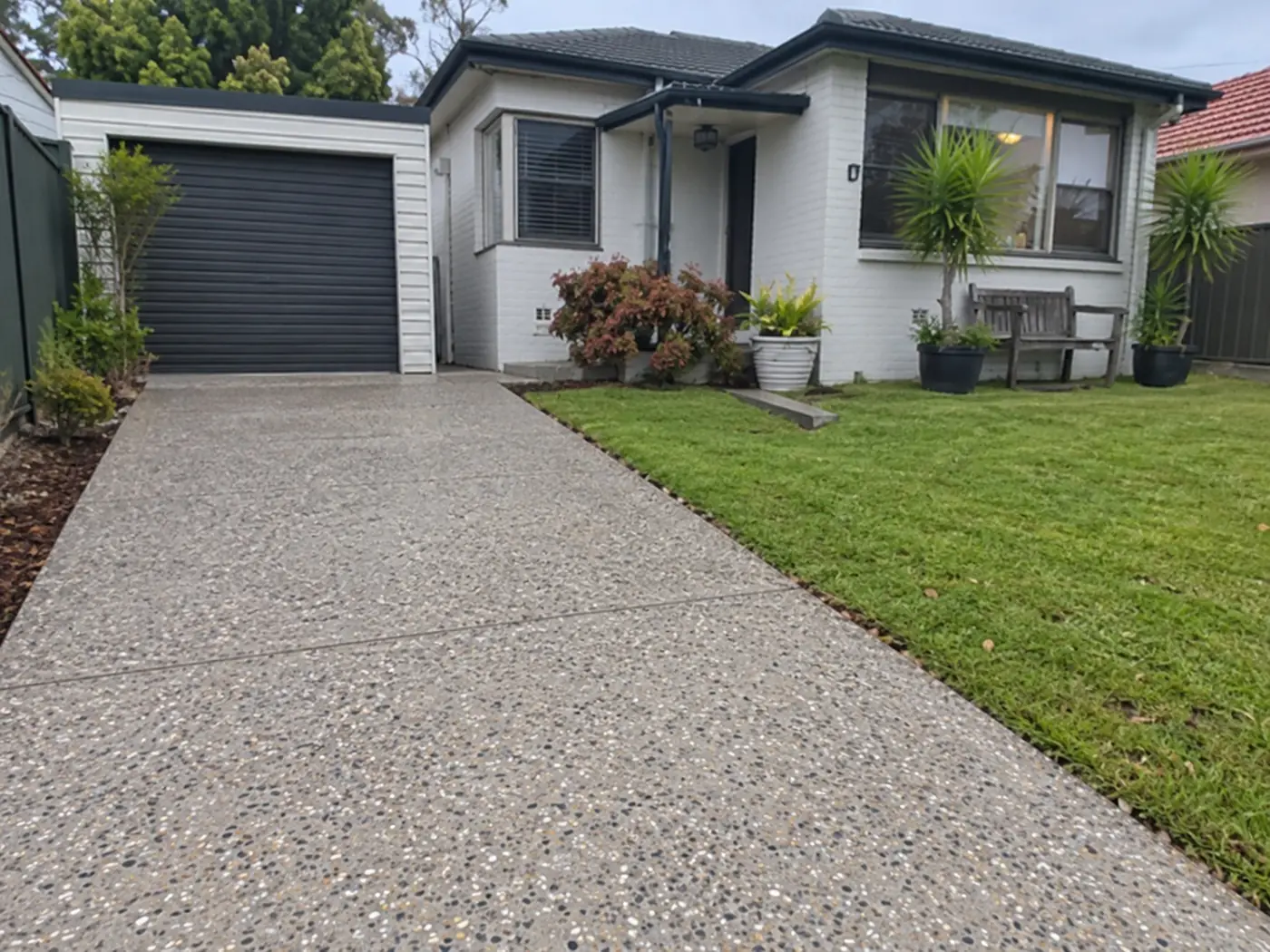 Exposed aggregate driveway leading to a single garage in Wollongong